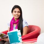 A student reading through a "graduate jobs" booklet