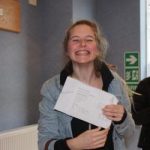 a smiling student with their exam results