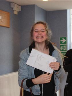 a smiling student with their exam results