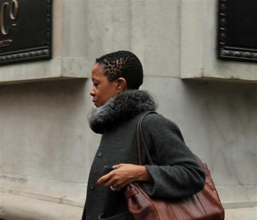 A woman with a grey coat on walking