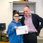 girl stood holding a certificate with her teacher