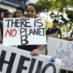 protestors outside protesting against the government's rules on protecting the planet