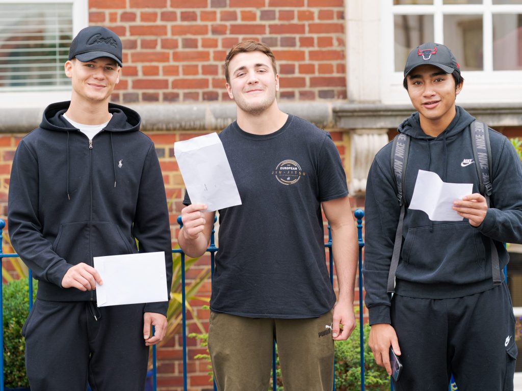 boys holding their exam results