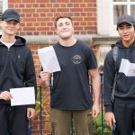 boys holding their exam results