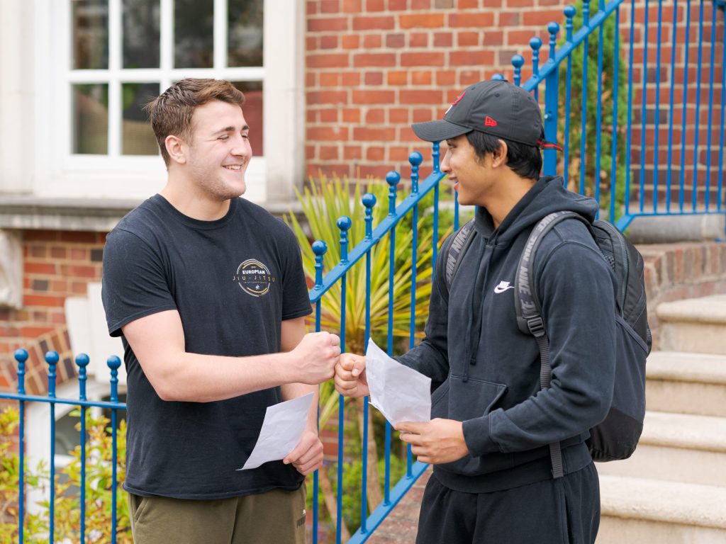 two male students bumping their fists