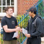 two male students bumping their fists