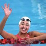 girl in a swimming pool waving