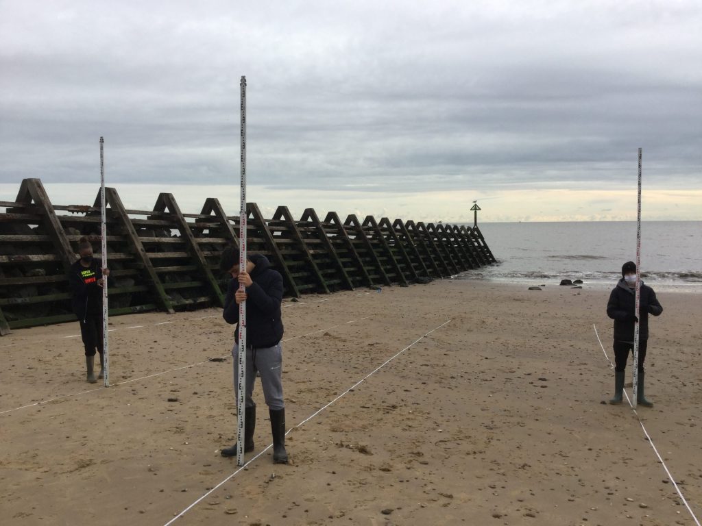 school children on geography trip to beach