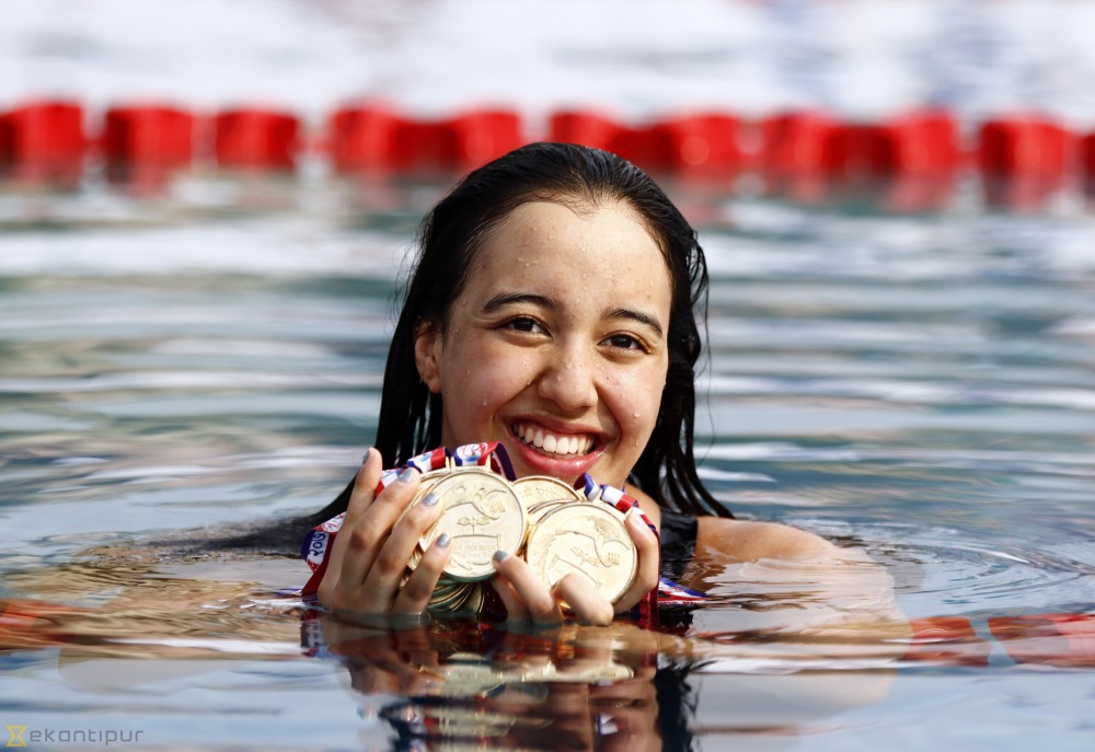 girl in pool with swimming medals