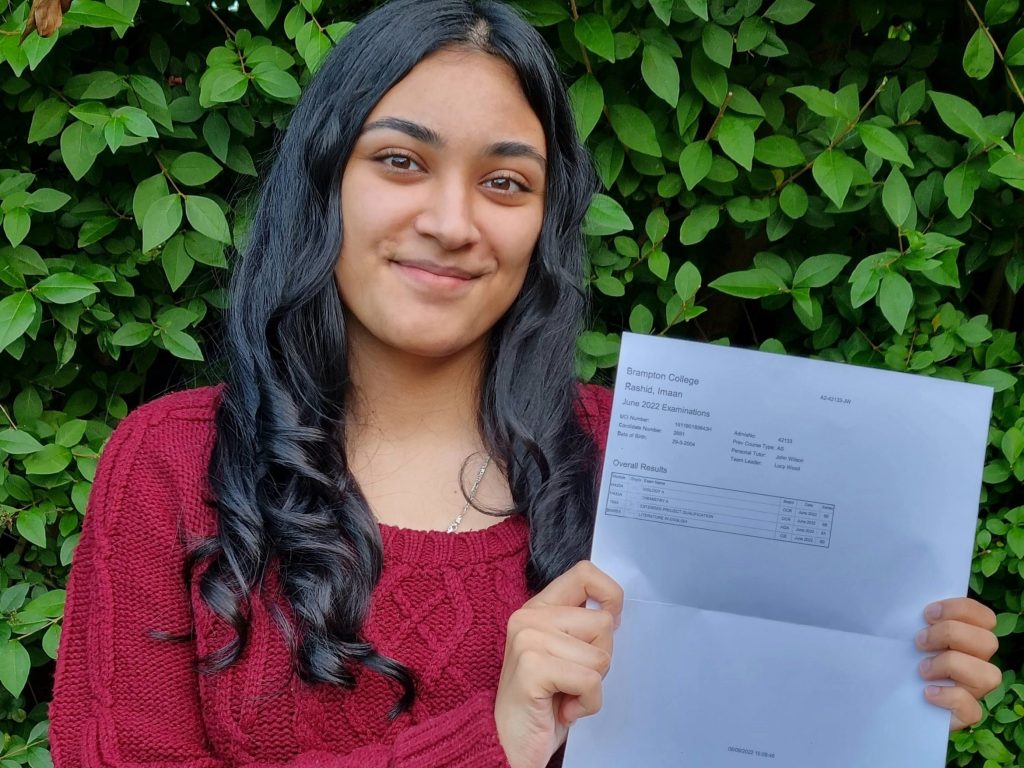 student holding her results up