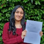 student holding her results up