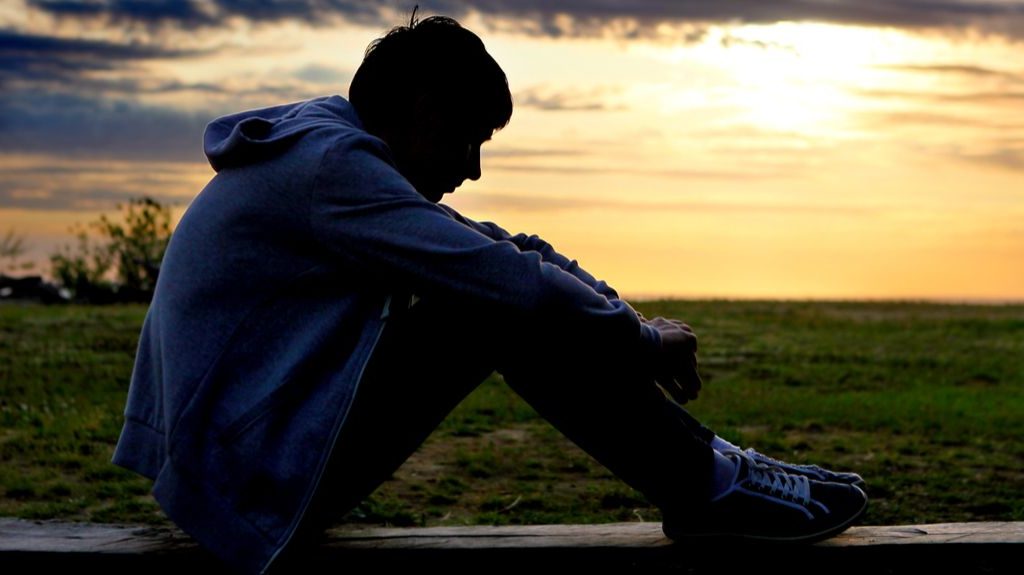 a boy sitting alone