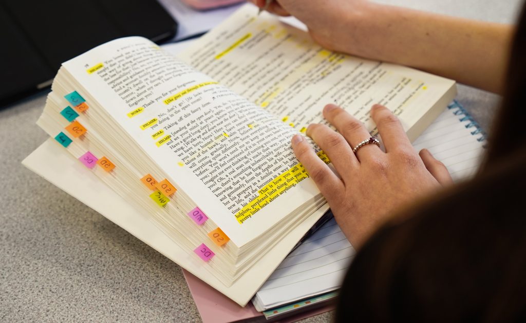 student looking through a book with yellow highlighted sentences