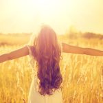 girl in field with outstretched arms