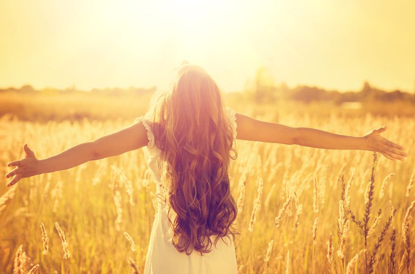 girl in field with outstretched arms