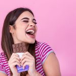 Girl smiling with a chocolate bar in their hands