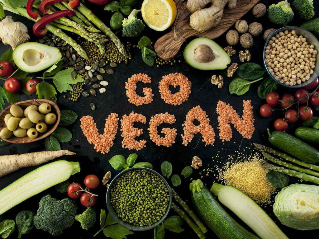 Image of vegetables, lentils in the middle forming the words "Go Vegan"