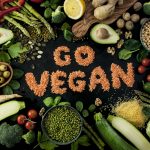 Image of vegetables, lentils in the middle forming the words "Go Vegan"