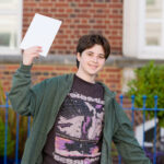 student holding his exam results